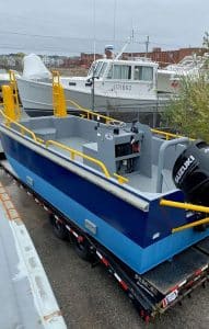 Fitzgerald Metalworks. Blue barge work boat on trailer.