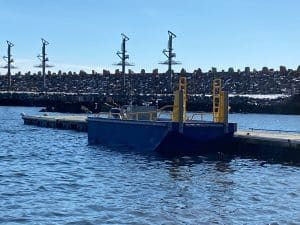 Fitzgerald Metalworks. A small utility barge or workboat docked at a marina.