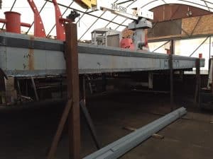 Fitzgerald Metalworks. A barge supported by metal stands for stability during construction or maintenance.