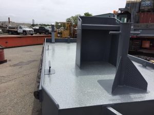 Fitzgerald Metalworks. a close-up view of the deck of a small workboat or utility barge in an industrial yard.