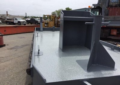 Fitzgerald Metalworks. a close-up view of the deck of a small workboat or utility barge in an industrial yard.