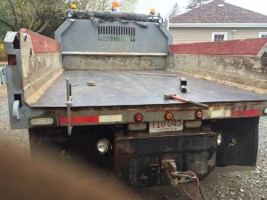 Fitzgerald Metalworks. The rear view of a flatbed truck with a raised dump bed