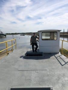 Fitzgerald Metal Works. White Cabin on barge with worker standing next to the cabin