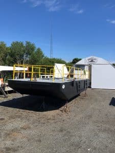 Fitzgerald Metal Works. Black barge hull with yellow iron railings