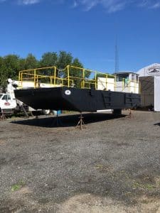 Fitzgerald Metal Works. Black barge hull with yellow iron railings