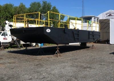 Fitzgerald Metal Works. Black barge hull with yellow iron railings