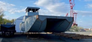 Fitzgerald Metalworks. A large catamaran-style workboat or barge on dry land, supported by stands for maintenance or construction.