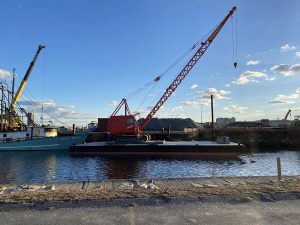 Fitzgerald Metalworks. Red and black Crane Barge on water.