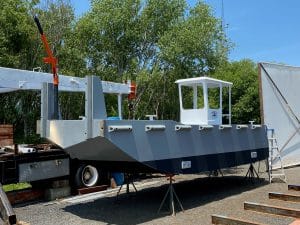 Fitzgerald Metalworks. A new grey and white workboat on support stands outside.