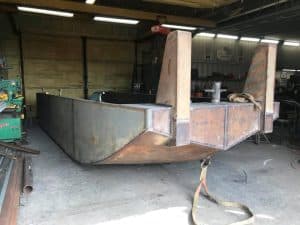 Fitzgerald Metal Works. A detailed view of a metal boat hull inside a workshop.