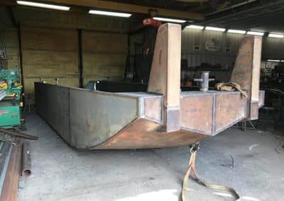 Fitzgerald Metal Works. A detailed view of a metal boat hull inside a workshop.