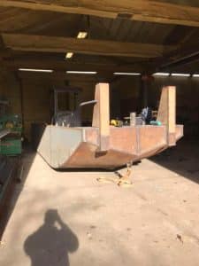 Fitzgerald Metal Works. A metal boat hull inside a workshop.