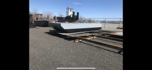 Fitzgerald Metalworks. Black and grey barge boat in boat yard