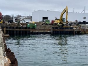 Fitzgerald Metalworks. Marine Construction Site on water's edge. Yellow excavator in background