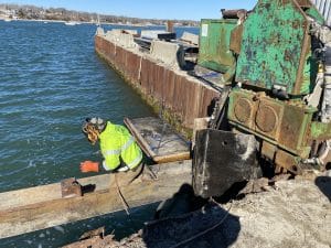 Fitzgerald Metal Works. Worker Welding a piece of metal on the waters edge.