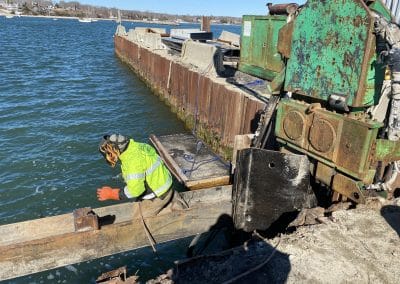 Fitzgerald Metal Works. Worker Welding a piece of metal on the waters edge.