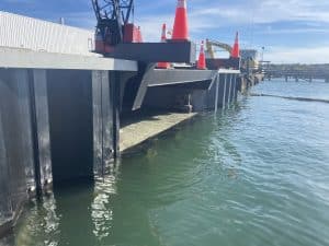 Fitzgerald Metalworks. black pillars holding machinery above a body of water.