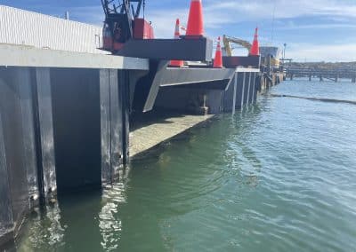 Fitzgerald Metalworks. black pillars holding machinery above a body of water.