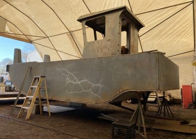 Fitzgerald Metal Works. A grey barge in a work area tent