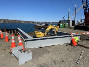 Fitzgerald Metal Works. Marine construction with water views. Yellow Machine in center of beams.