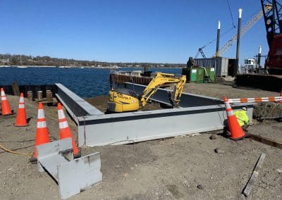 Fitzgerald Metal Works. Marine construction with water views. Yellow Machine in center of beams.