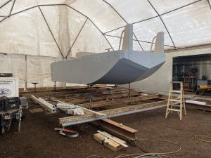 Fitzgerald Metal Works. A boat under construction inside a large, enclosed tent or workshop.