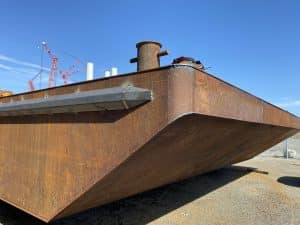 Fitzgerald Metalworks. Rusty bottom hull of a barge boat on a concrete ground