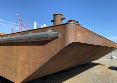 Fitzgerald Metalworks. Rusty bottom hull of a barge boat on a concrete ground