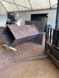 Fitzgerald Metalworks. A welder at work in a workshop, actively welding a large metal component