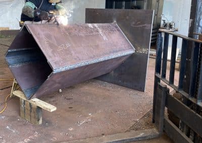 Fitzgerald Metalworks. A welder at work in a workshop, actively welding a large metal component