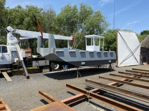 Fitzgerald Metalworks. A barge vessel under construction, positioned outdoors in a boatyard.