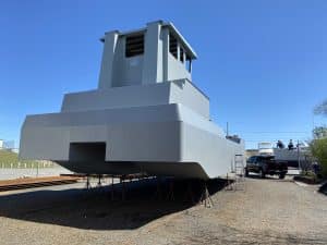 Fitzgerald Metalworks. A large gray catamaran-style barge vessel under construction