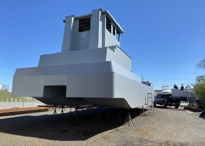 Fitzgerald Metalworks. A large gray catamaran-style barge vessel under construction