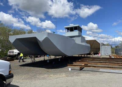 Fitzgerald Metalworks. A large catamaran-style barge boat under construction in an outdoor work area.