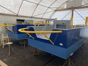 Fitzgerald Metalworks. Two barge boats under construction in a covered workshop area.