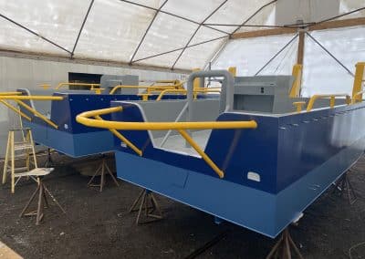 Fitzgerald Metalworks. Two barge boats under construction in a covered workshop area.