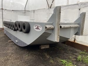 Fitzgerald Metalworks. A gray metal barge in a workshop tent.