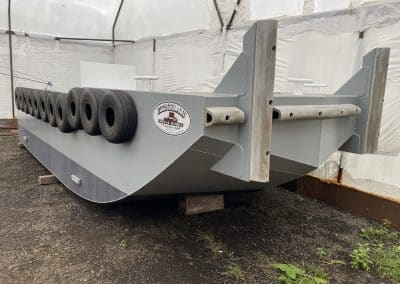 Fitzgerald Metalworks. A gray metal barge in a workshop tent.