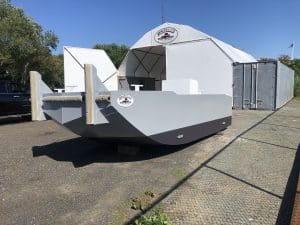 Fitzgerald Metalworks. A newly constructed barge outdoors near a "Fitzgerald Metal Works" tent