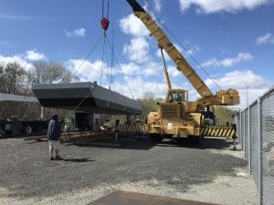 Fitzgerald Metal Works. A large yellow crane lifting a grey barge