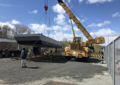 Fitzgerald Metal Works. A large yellow crane lifting a grey barge