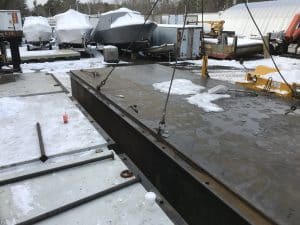 Fitzgerald Metal Works. marine industrial area during winter with a large metal structure attached to a crane