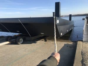 Fitzgerald Metal Works. Large black barge being launched into the water