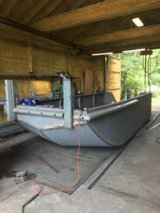 Fitzgerald Metal Works. Front view of metal boat hull in process of being constructed in workshop