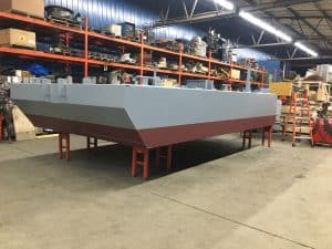 Fitzgerald Metal Works. Boat hull construction. Grey and maroon boat hull.