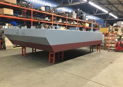 Fitzgerald Metal Works. Boat hull construction. Grey and maroon boat hull.