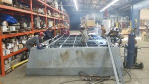 Fitzgerald Metal Works. Marine fabrication professionals working on constructing a barge boat