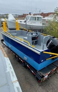 Fitzgerald Metalworks. Blue barge work boat on trailer.